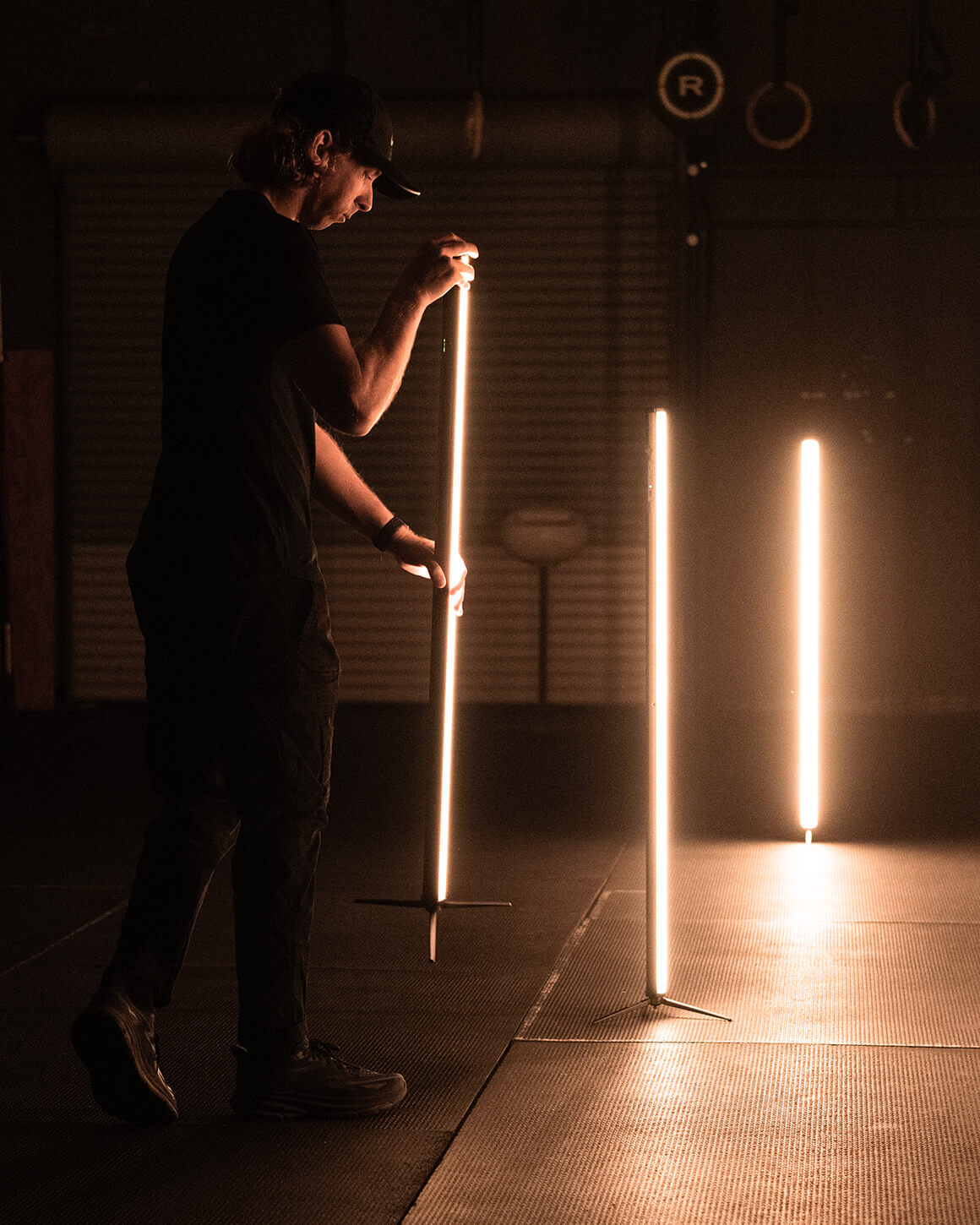 Man arranging 3 RGB Tube Light XL Lights on stands