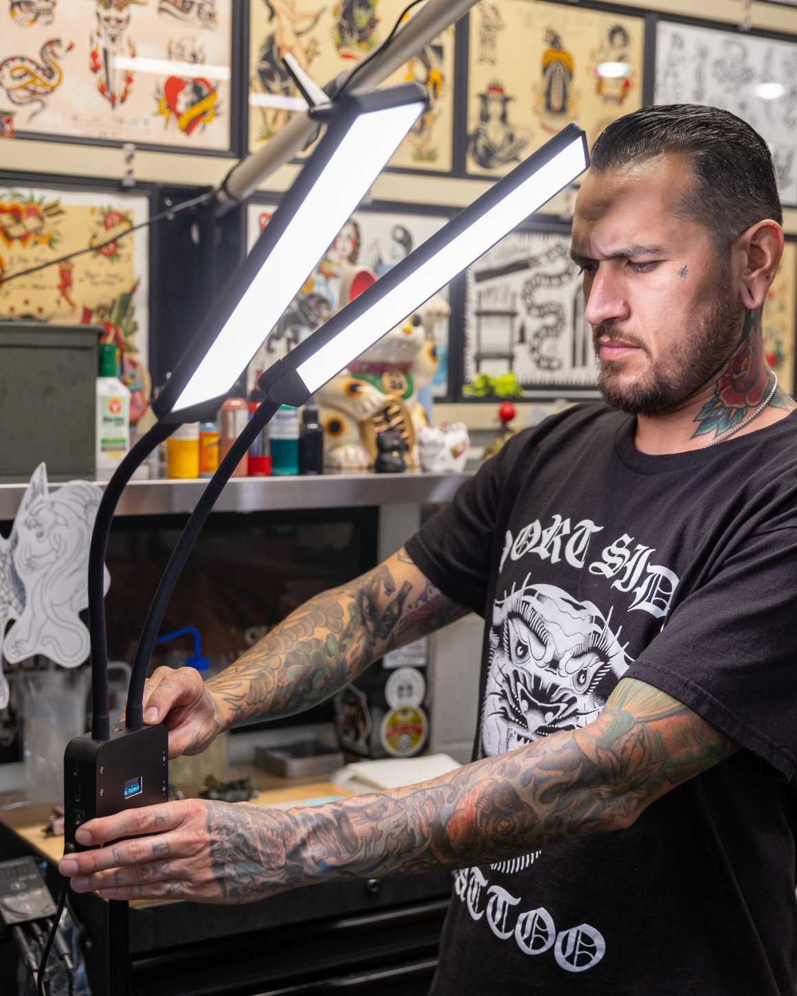 Tattoo artist adjusting Flex Light Pro control panel LC-FLEXPRO