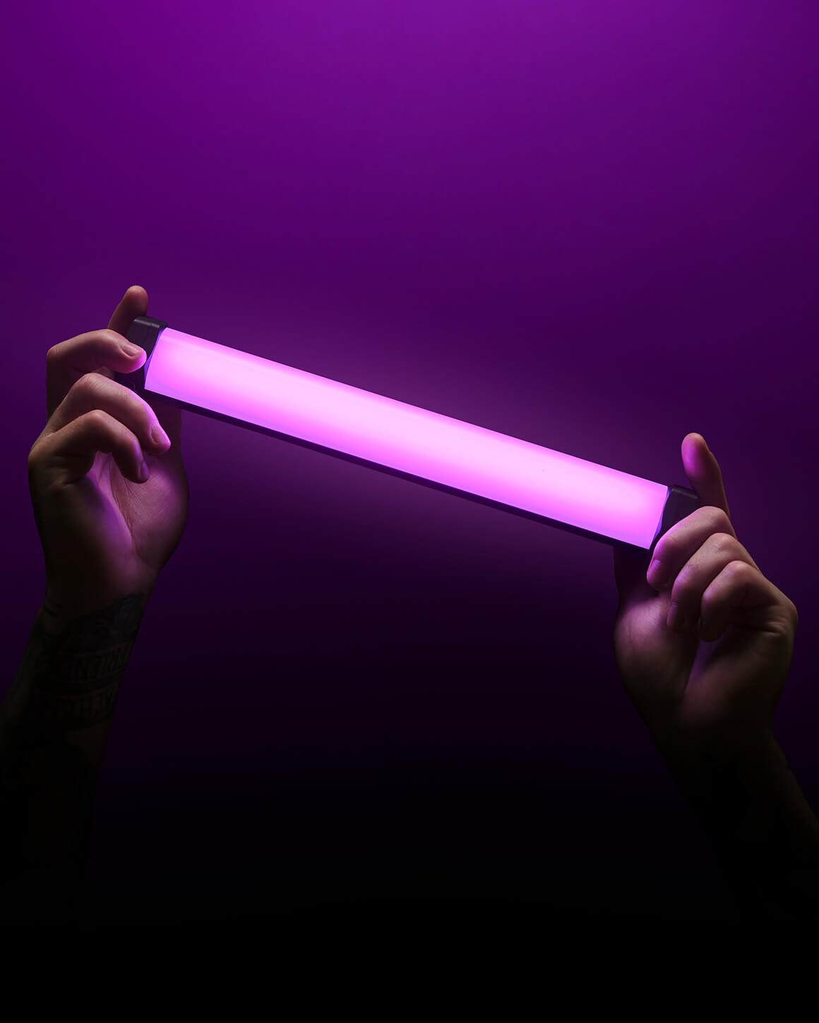 Person holding RGB Tube Light Mini on dark background #color_rgb tube light mini 2-pack