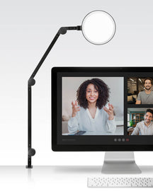 Adjustable black LED ring light with flexible arm for video calls and streaming, mounted on a computer monitor.