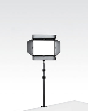 Black Edge-Mounted Light Stand with a Lume Cube Studio Panel with barn doors attached.