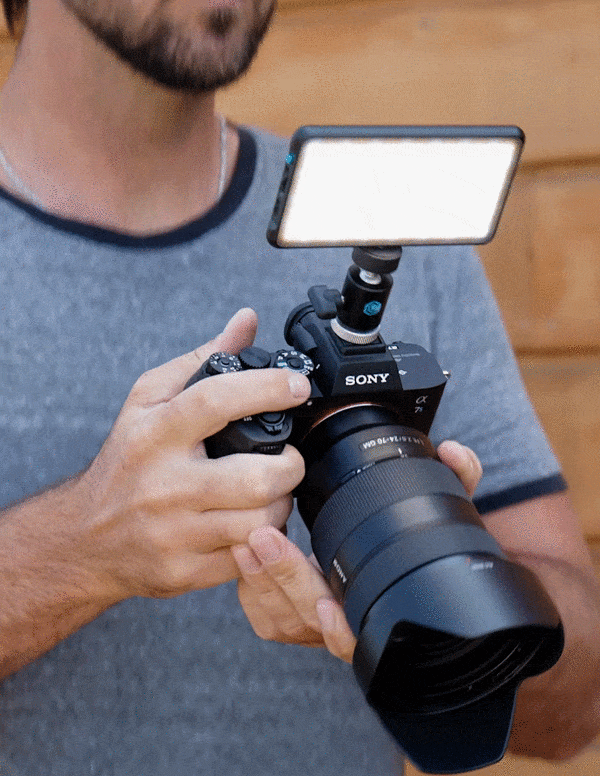 Animated gif of man holding Panel Go Light mounted to DSLR camera