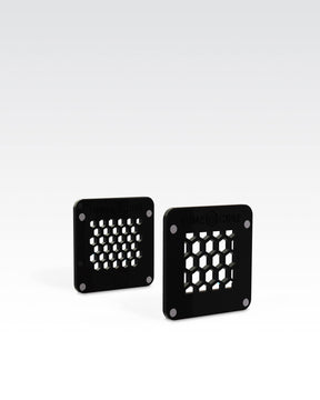 Two separate black plastic 1" square magnetic Honeycomb Grids modifiers for Lume Cube 2.0 Waterproof LED for adventure photography lighting.