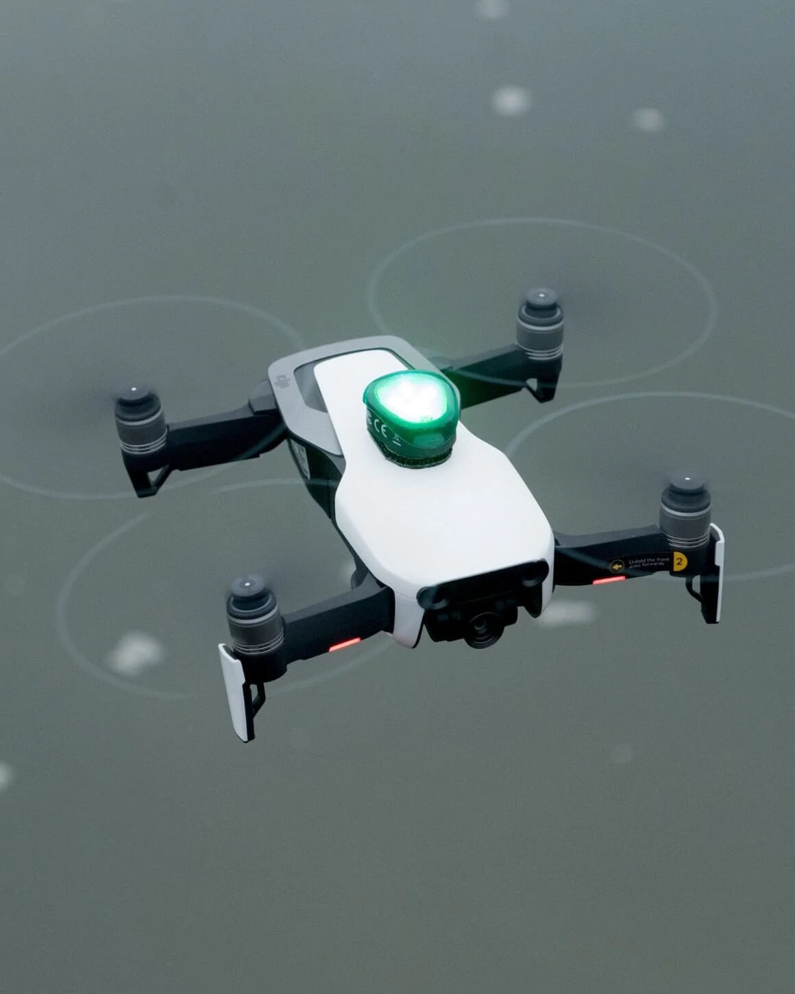 Black and white drone with Lume Cube Strobe Anti-Collision Lighting mounted on top using the Green plastic cover cap.